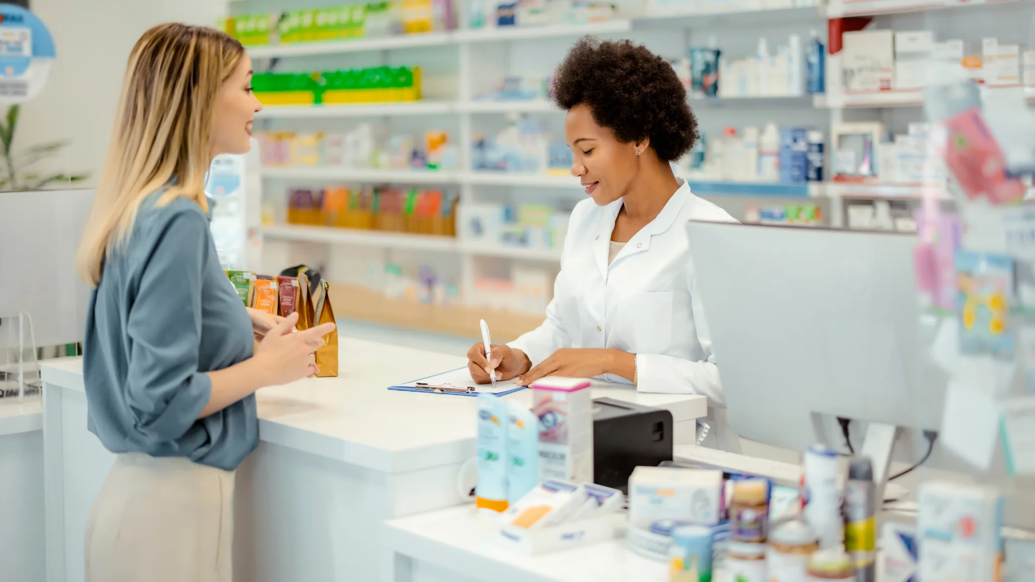 Farmacêutica atende cliente no balcão de uma farmácia, ilustrando o case de gestão comercial no varejo farmacêutico